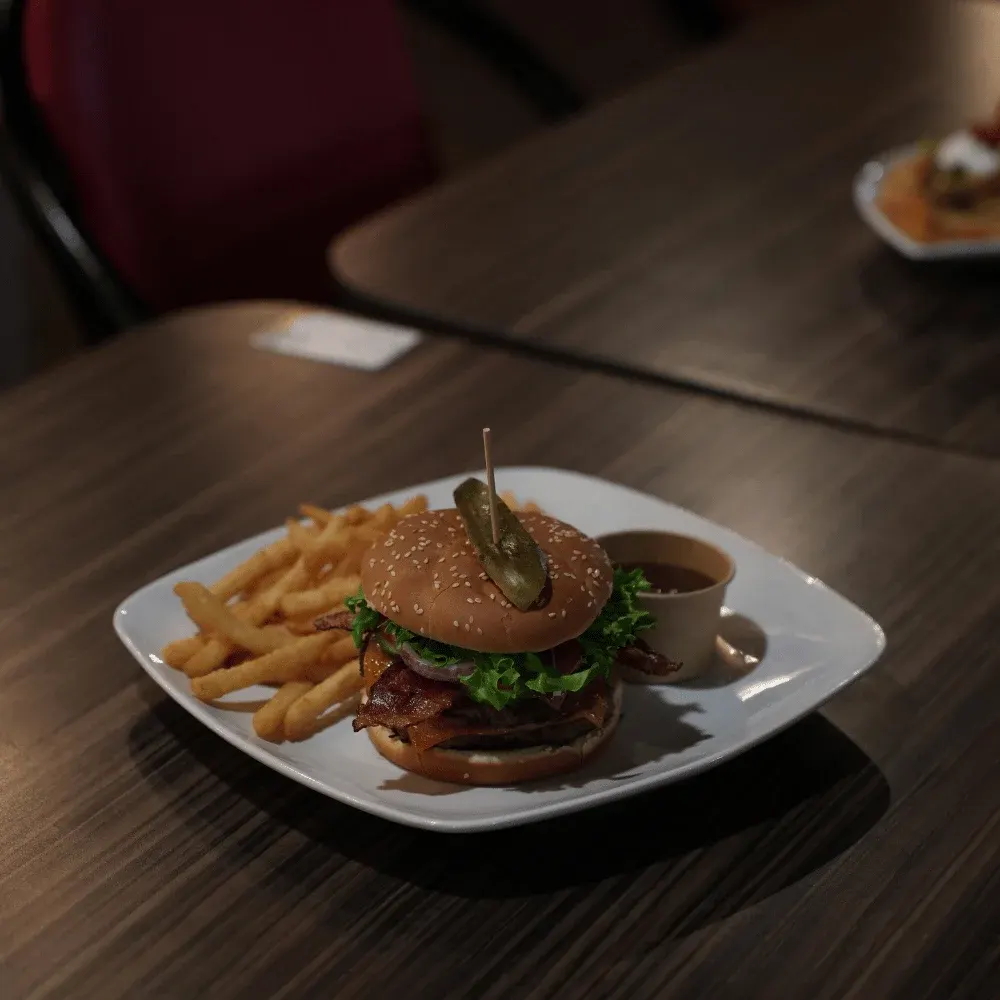 A bacon cheeseburger with fries and dipping sauce at Kicks Saloon