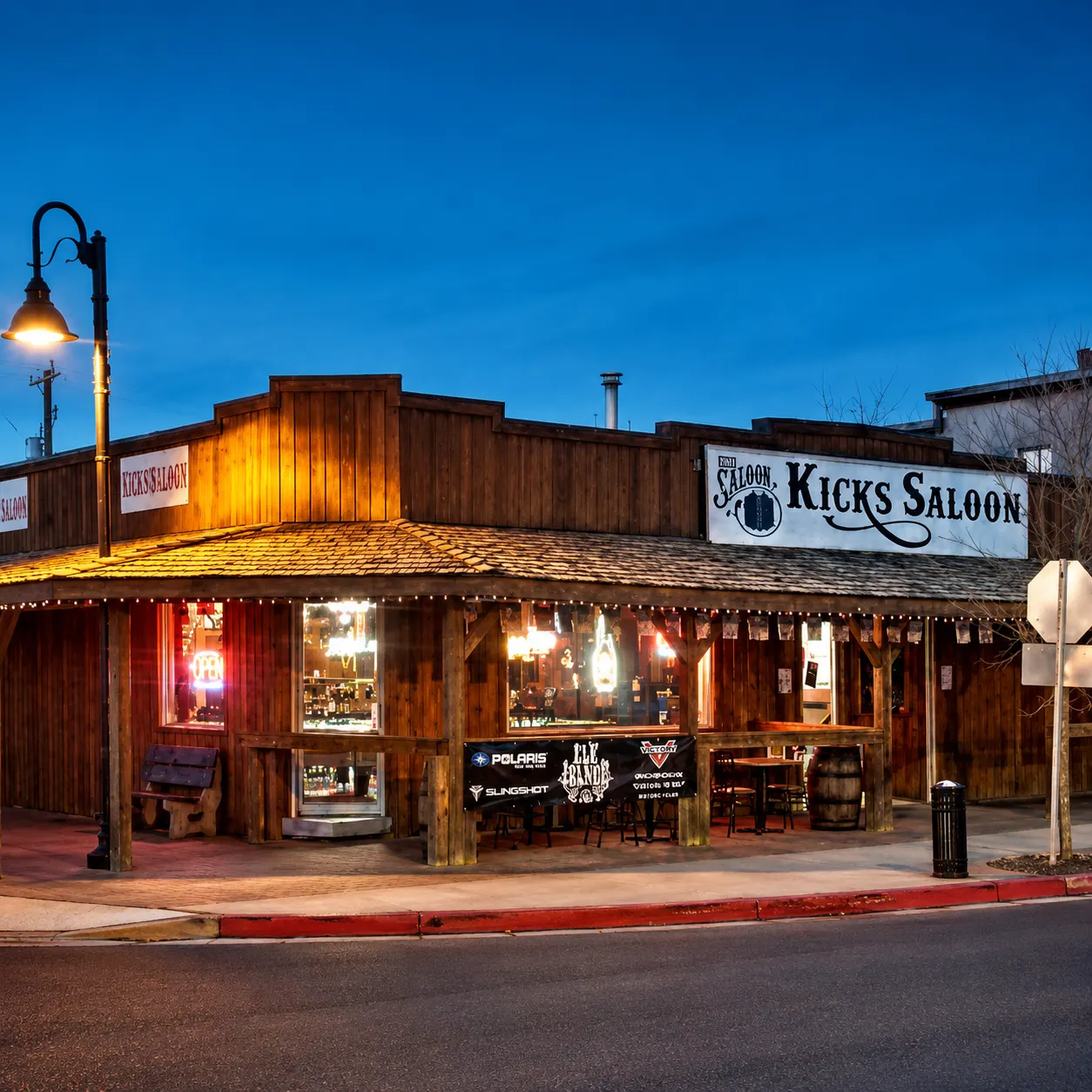 Kicks Saloon storefront at dusk on 49 Avenue, Redwater