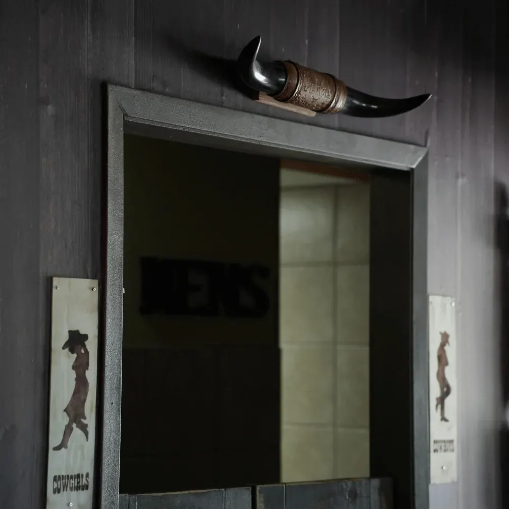 Longhorns and cowgirl signs above the saloon doors